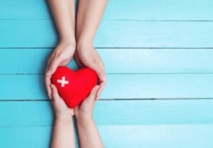foto de un corazon tipo sanitario con fondo azul uniendo dos manos simbolo de comunicacion offline al online en parafarmacia online
