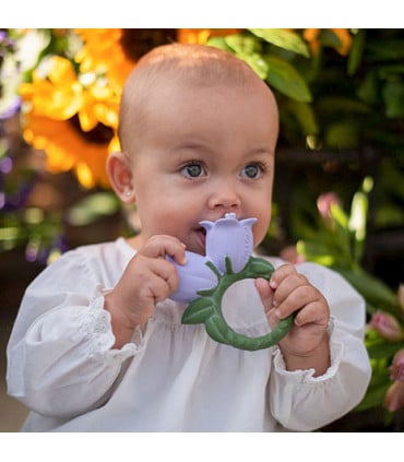 foto de un bebe mordiendo una de las flores del mordedor para bebes de oli and carol cindy th bellflower con forma de flor campanilla doble y con un tallo en forma redonda para un mejor agarre