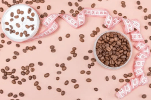 foto de granos de café con cinta metrica como soluciones a la reduccion de la grasa abdominal