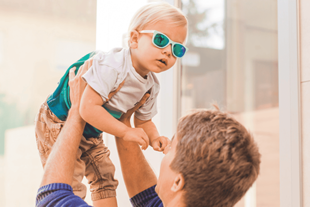 foto de un niño con las gafas infantiles suavinex con su padre cogiendolo en el aire