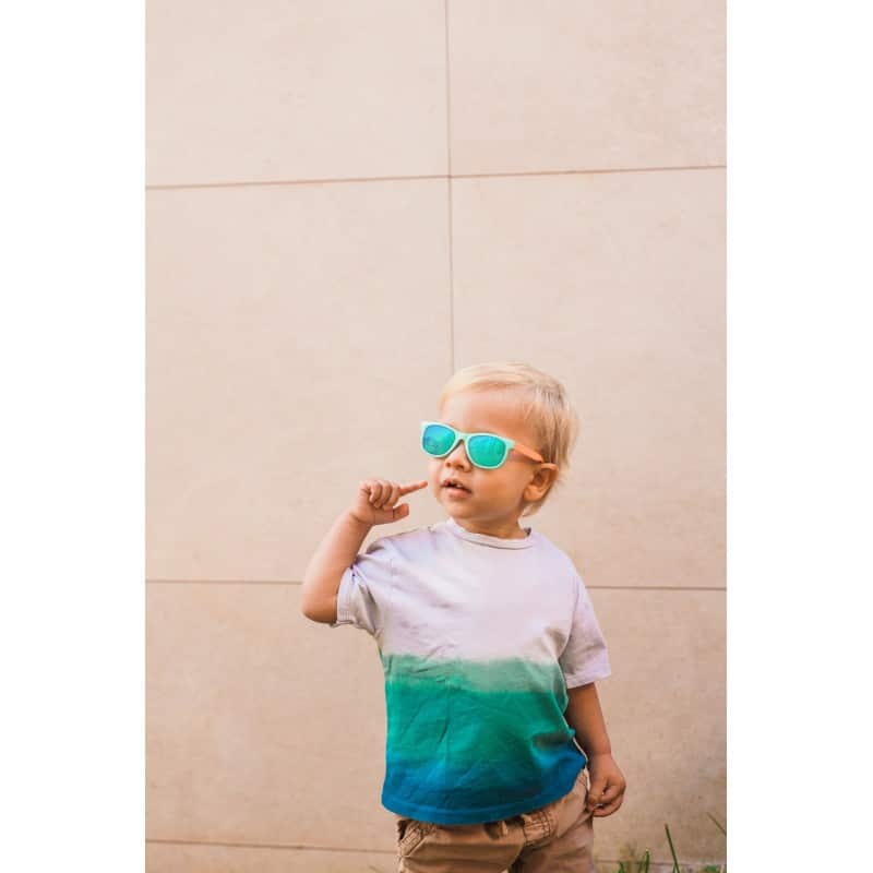 foto de un niño con gafas de sol niños suavinex con una camisa de diseño moderno con las gafas puestas en color azul y naranja con los cristales de espejo polarizados